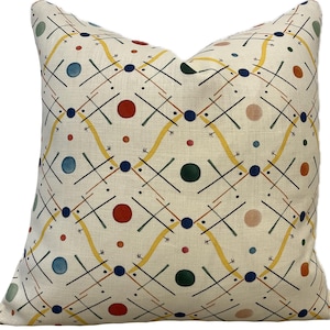 Peut inclure: Un oreiller de couleur crème avec un motif géométrique composé de cercles et de lignes jaunes, rouges, bleus et verts.