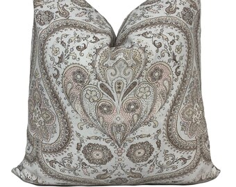 May include: A decorative throw pillow with a paisley pattern in shades of brown, pink, and gray on a white background.