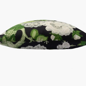 May include: A black pillow with a white and green floral pattern.