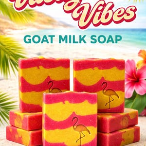May include: Goat milk soap bars with a tropical theme. The bars are red and yellow with a flamingo design. The image includes the text "Vacay Vibes" and "Goat Milk Soap" against a beach background.