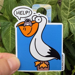 May include: A white pelican with a large orange beak is holding a small gray mouse in its beak. The mouse is saying "HELP!" in a speech bubble. The pelican has large, round eyes and a black wing. The background is blue. The sticker has the text "KALI RALLY.COM" in the bottom right corner.