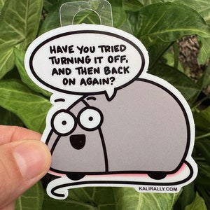 May include: A gray cartoon mouse with big eyes and a speech bubble above its head. The speech bubble says "Have you tried turning it off, and then back on again?" The mouse is on a white background with a pink line underneath it. The text "kalirally.com" is at the bottom of the image.