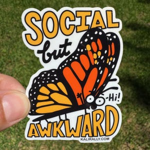 May include: A white sticker with a black and orange butterfly with the text "Social but awkward - Hi!" and the website "kalirally.com" at the bottom.