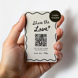 May include: A cream-colored card with black wavy border and text that reads "Share the Love" with a heart symbol. A QR code is below the text, with the words "Scan the code to share your photos with us!" and "xoxo, Sia + Mike". A black circle says "2 styles included".