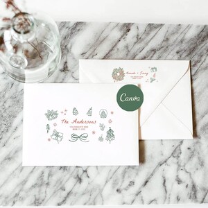 Könnte beinhalten: Zwei weiße Umschläge mit festlichen Illustrationen und Text. Ein Umschlag zeigt ein Kranzdesign und die Namen "Amanda + Jimmy". Der andere Umschlag trägt den Namen "The Andersons" und Adressdetails sowie festliche Zeichnungen von Geschenken, Bäumen und Ornamenten.