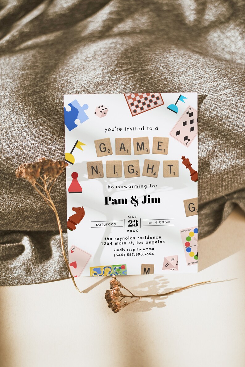 May include: A white invitation card with colorful illustrations of game pieces and a white background. The text reads "You're invited to a Game Night housewarming for Pam & Jim, Saturday, May 23, 20XX at 4:00pm, The Reynolds Residence, 1234 Main St, Los Angeles, Kindly RSVP to Emma (345) 567.890.7654".