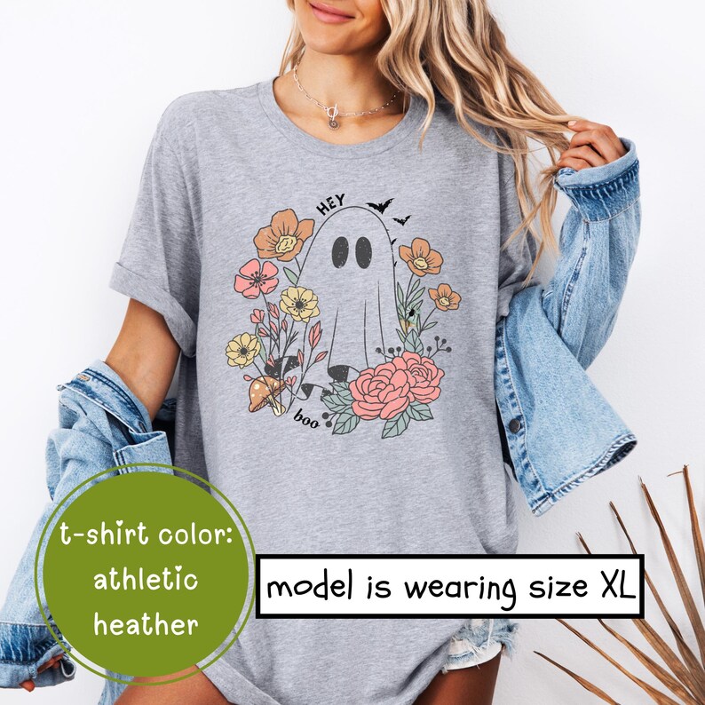 May include: A heather grey t-shirt with a cute ghost wearing flowers and the text "Hey Boo".