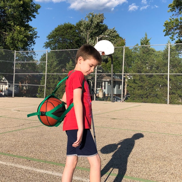 Carry your Basketball, Soccer Ball, or Vollyball in style with the B-BALL SLING over-the-shoulder athletic ball carrier!