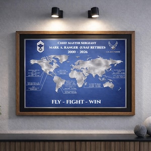 May include: A framed world map with a blue background and silver continents. The text "CHIEF MASTER SERGEANT MARK A. RANGER (USAF RETIRED) 2000 - 2026" is displayed at the top. The words "FLY - FIGHT - WIN" are at the bottom.