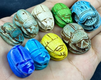 Conjunto de nueve pequeños escarabajos egipcios de diferentes colores. Escultura única en piedra tallada con hermosos colores arte egipcio hecha en Egipto