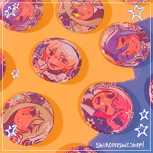 May include: A collection of round, colorful buttons with anime-style character illustrations. The buttons feature shades of pink, purple, and orange, with star and floral accents. The background is a vibrant orange and blue. The text "Shiroplushie shop!" is visible.