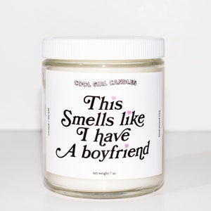 Puede incluir: Un tarro de vela blanco con una tapa blanca. La etiqueta dice "COOL GIRL CANDLES" y "This Smells like I have A boyfriend". La vela pesa 7 oz.