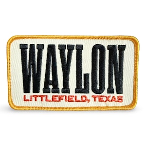 May include: Embroidered patch featuring the name "WAYLON" in black, above "LITTLEFIELD, TEXAS" in red. The patch has a cream background and a gold border.