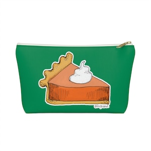 May include: Green zippered pouch with a drawing of a slice of pumpkin pie with whipped cream on top. The text "@fruity.donut" is at the bottom of the image.