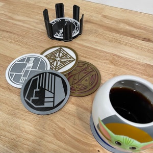Könnte beinhalten: Satz mit sechs Untersetzern mit verschiedenen Designs zum Thema Star Wars. Die Untersetzer sind aus strapazierfähigem Material gefertigt und schützen Ihre Möbel perfekt vor Flecken und Kratzern.