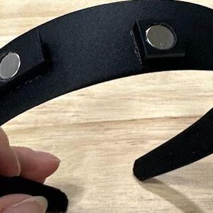 May include: A black headband with four silver magnetic closures.