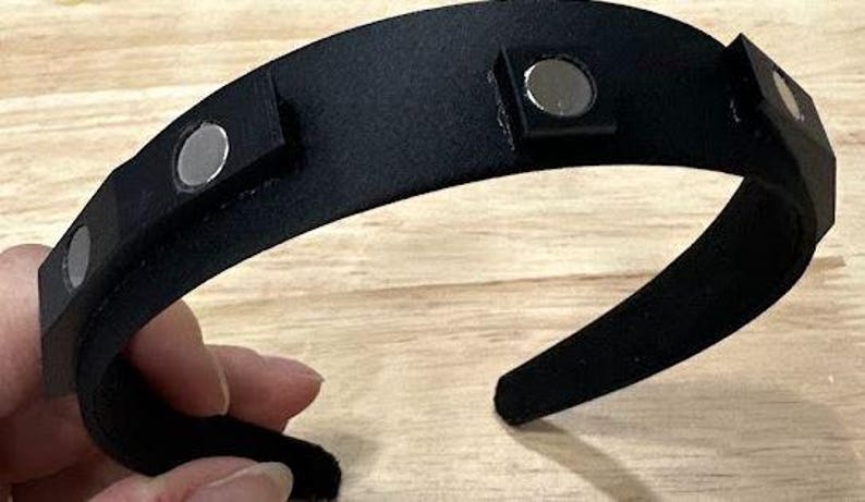 May include: A black headband with four silver magnetic closures.