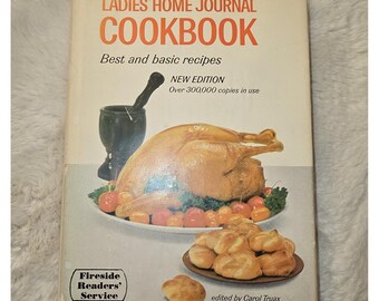 May include: The Ladies' Home Journal Cookbook, edited by Carol Truax, features a white cover with orange text. The cover displays a roasted turkey on a platter with vegetables, a black mortar and pestle, and a plate of golden brown dinner rolls.