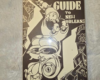 May include: A rectangular book titled GOURMETS GUIDE TO NEW ORLEANS with a dark brown and cream graphic cover. The illustration features stylized buildings, a pig, ducks, and cooking pots in a bold, high-contrast, two-tone artistic style.