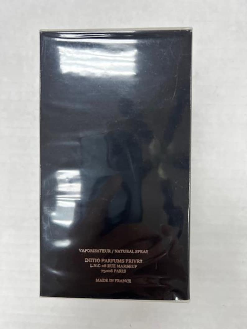 Puede incluir: Caja rectangular negra con texto blanco que dice "VAPORISATEUR/NATURAL SPRAY", "INITIO PARFUMS PRIVES", "LN.C-18 RUE MARBEUF", "75008 PARIS" y "MADE IN FRANCE".