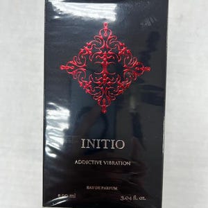 Puede incluir: Una botella negra de Initio Addictive Vibration Eau de Parfum. La botella tiene un dise&ntilde;o rojo y dorado con el nombre de la marca y el nombre de la fragancia impresos en la parte delantera. La botella es de 90 ml.
