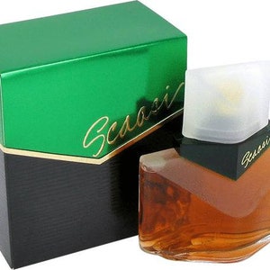 May include: A green and black box with the word "Scasso" on it. The box contains a clear glass bottle of perfume with a brown liquid. The bottle has a green and black cap with the word "Scasso" on it.