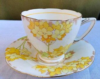 Circa 1935. A.B.J Made in England Style 8431 Grafton China White with Delicate Yellow Floral and Vine Pattern Tea Cup and Saucer