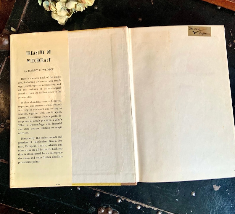 Puede incluir: Un libro vintage titulado "Treasury of Witchcraft" de Harry E. Wedeck. La portada del libro es blanca con texto negro y una columna vertebral amarilla. La contraportada tiene una descripci&oacute;n del contenido del libro, incluida informaci&oacute;n sobre la historia de la brujer&iacute;a y sus pr&aacute;cticas.
