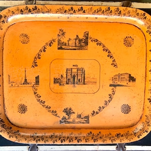 May include: A vintage metal tray with a gold-colored border and a light orange background. The tray features black and white images of famous landmarks, including an archway, a building, and a tower.