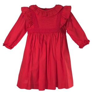 May include: A red long-sleeved dress with a ruffled collar and a gathered skirt.