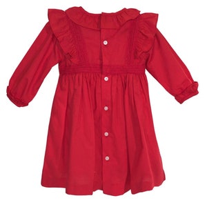 May include: A red long-sleeved dress with a ruffled collar and a button-up front. The dress has a gathered skirt and is made of a lightweight fabric.