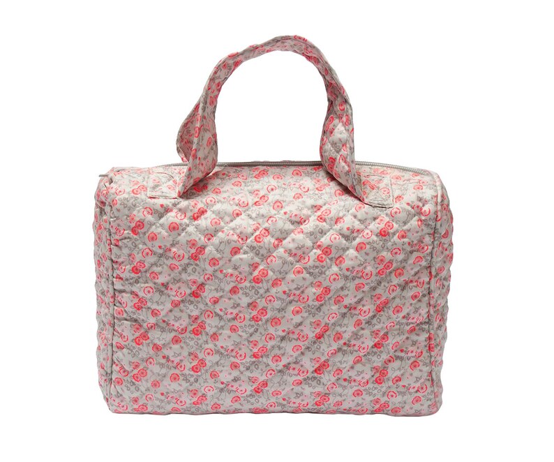 K&ouml;nnte beinhalten: Eine graue gesteppte Reisetasche mit einem rosafarbenen Blumenmuster. Die Tasche hat einen einzigen oberen Griff und einen Rei&szlig;verschluss.