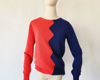 Puede incluir: Un suéter rojo y azul con un patrón de zigzag en el centro.