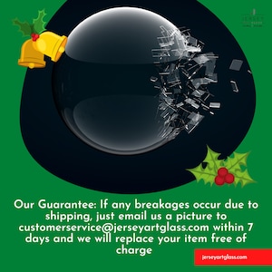 May include: A broken glass ornament with a green holly sprig and red berries on a green background. The text "Our Guarantee: If any breakages occur due to shipping, just email us a picture to customerservice@jerseyartglass.com within 7 days and we will replace your item free of charge" is displayed below the ornament. The text "jerseyartglass.com" is displayed at the bottom of the image.