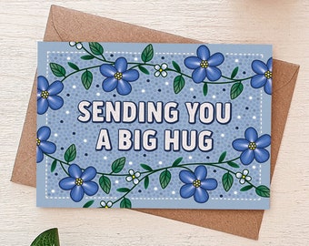 May include: A blue card with a white background and a floral border. The card says "Sending you a big hug".
