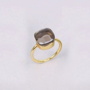 Może przedstawiać: Złoty pierścionek z kwadratowym, dymnym kwarcem.