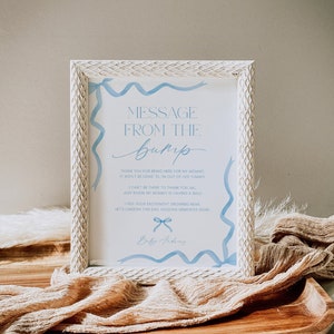 Può includere: Una cornice bianca con un messaggio blu e bianco dal pancione. Il messaggio dice "Grazie per essere qui per la mia mamma, non passerà molto tempo prima che io esca dalla sua pancia. Non posso essere lì per ringraziarvi tutti, sappiate solo che la mia mamma si sta divertendo un mondo! Sento la vostra eccitazione crescere, custodiamo questo giorno, conservando ricordi cari. Baby Andrews"