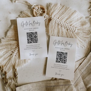 May include: Two white cards with black text and a black and white QR code. The text on the cards reads "Gifts for Baby", "Alice's Baby Shower", "28.11.23", "Alice and Baby Hanson are registered at Amazon.com. Kindly scan to view the gift registry." and "thank you".