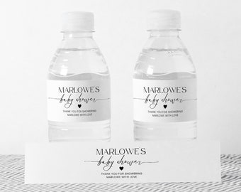 Könnte beinhalten: Zwei durchsichtige Plastikwasserflaschen mit schwarzen und weißen Etiketten, auf denen "Marlowe's baby shower" mit einem kleinen Herzsymbol steht. Die Etiketten sagen auch "Vielen Dank, dass Sie Marlowe zum Baby Shower gratulieren".