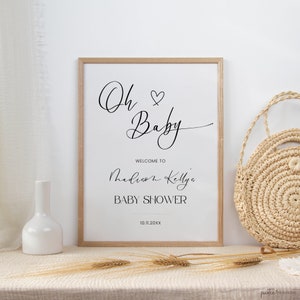 Op de afbeelding: Een wit bord met zwarte tekst dat "Oh Baby" met een hartje zegt. Het bord zegt ook "Welkom bij Madison Kelly's Baby Shower" en de datum "10.11.20XX".