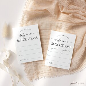 Może przedstawiać: Dwie białe karty z czarnym tekstem, na kt&oacute;rych napisano "Alice's Baby Shower baby name suggestions" z liniami do wpisania imion dla dziecka. Karta po prawej stronie ma oddzielne linie dla imion chłopięcych i dziewczęcych.