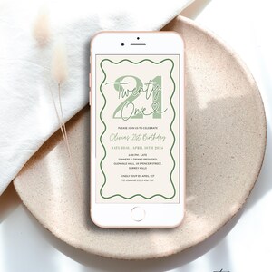 Peut inclure: Une invitation num&eacute;rique pour une f&ecirc;te de 21e anniversaire. L'invitation est con&ccedil;ue pour ressembler &agrave; l'&eacute;cran d'un smartphone et pr&eacute;sente une illustration verte et blanche du chiffre 21 avec le texte "Twenty One" et un c&oelig;ur. L'invitation comprend le texte "Veuillez vous joindre &agrave; nous pour c&eacute;l&eacute;brer le 21e anniversaire d'Olivia" et des d&eacute;tails sur la f&ecirc;te, y compris la date, l'heure, le lieu et les informations de RSVP.