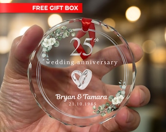 Könnte beinhalten: Ein klarer, runder Kristallschmuck mit dem Text "25. Hochzeitstag" und den Namen "Bryan & Tamara" mit dem Datum 21.10.1985. Der Schmuck hat ein rotes Band und florale Akzente. Die Worte "FREE GIFT BOX" stehen in einem roten Banner.