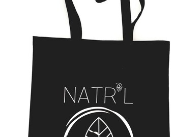 May include: Black tote bag with white text that reads "NATR'L" and a white circle with a stylized leaf inside.