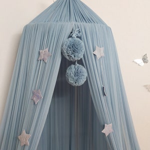 May include: A light blue canopy bed with a silver crown on top. The canopy is decorated with silver stars and two large blue pom-poms. The text "Color - Jeans" is visible in the upper right corner of the image.