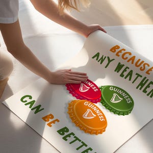 May include: A poster with the text "BECAUSE ANY WEATHER CAN BE BETTER" in green and orange. The poster features three bottle cap designs in red, green, and orange, each with the Guinness logo.