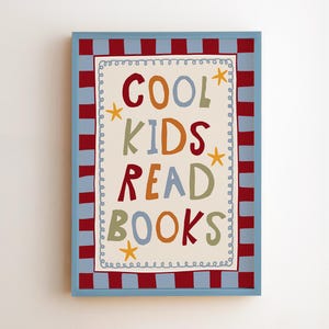 May include: A rectangular framed wall art piece featuring the text COOL KIDS READ BOOKS in multi-colored lettering. The design includes yellow star accents and a decorative border with a red and light blue checkered pattern on a cream background.