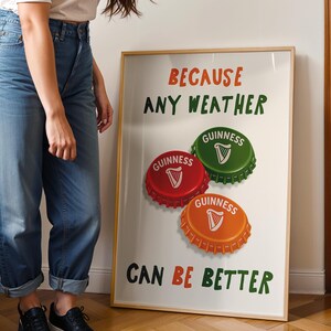 May include: A framed poster with the text "BECAUSE ANY WEATHER CAN BE BETTER." The poster features three Guinness bottle caps in red, green, and orange, each with a white harp symbol. The poster is displayed against a white background.