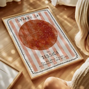 May include: A framed print with a star map design. The print features a reddish-brown celestial map within a striped border, with the text "STARRY SKY" at the top and "for JESSICA" below. The text "The sky above Toronto on November 2, 2018 at 11:44" is also included.