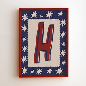 Puede incluir: Impresión enmarcada con la letra "H" roja, delineada en azul, sobre un fondo crema. La letra está dentro de un rectángulo crema, enmarcado por un borde azul marino con estrellas blancas, todo dentro de un marco rojo.